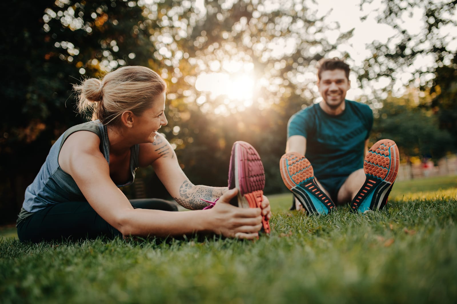 Couple Stretching Grass Sunset