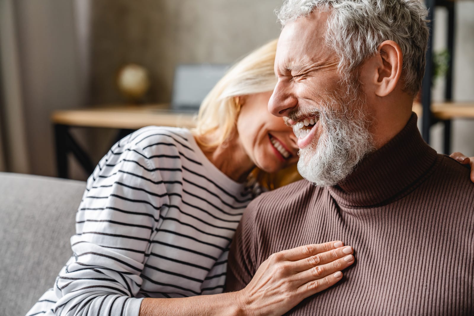 Senior Couple Laughing Embracing Sofa