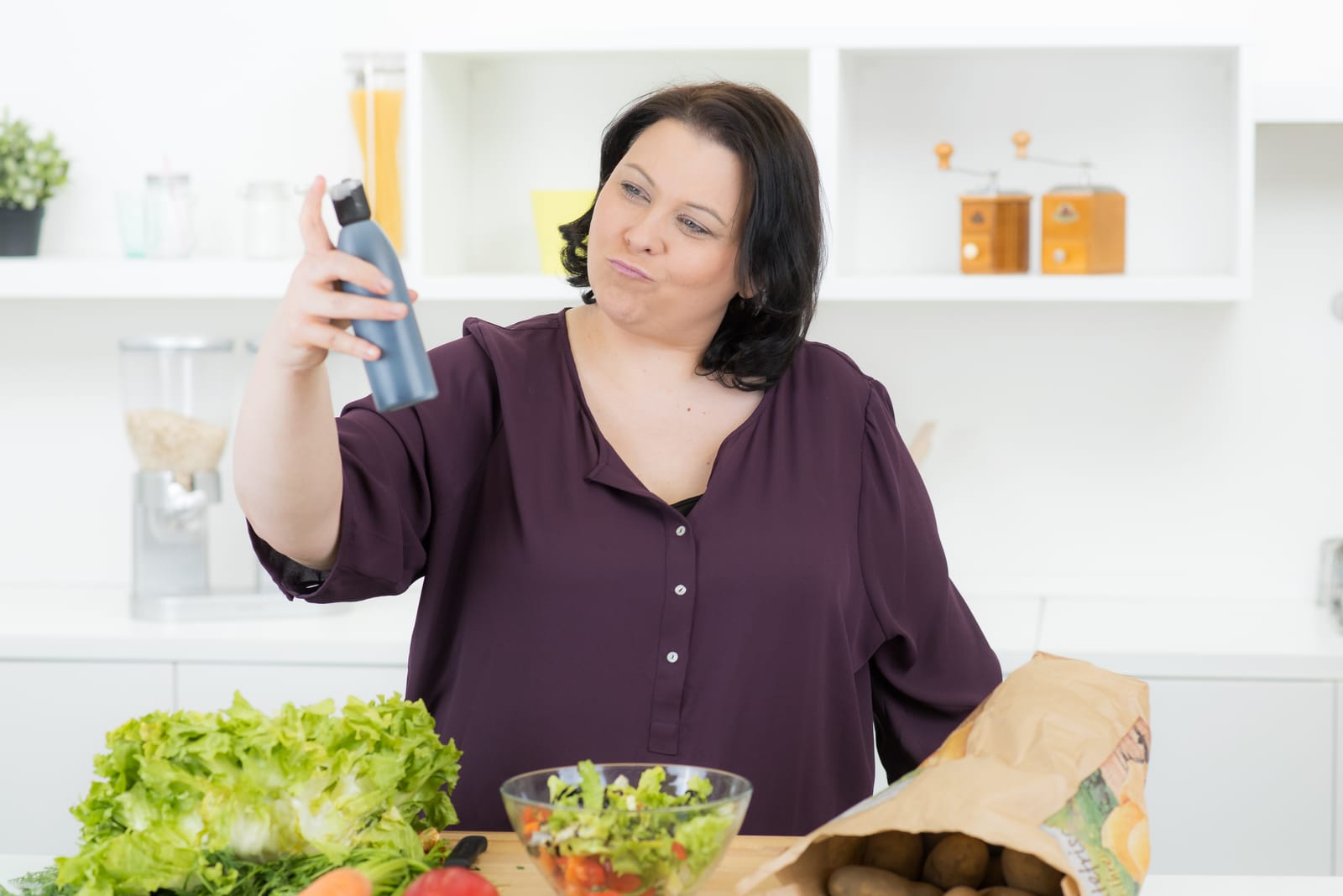 Woman Reading Bottle Label Kitchen